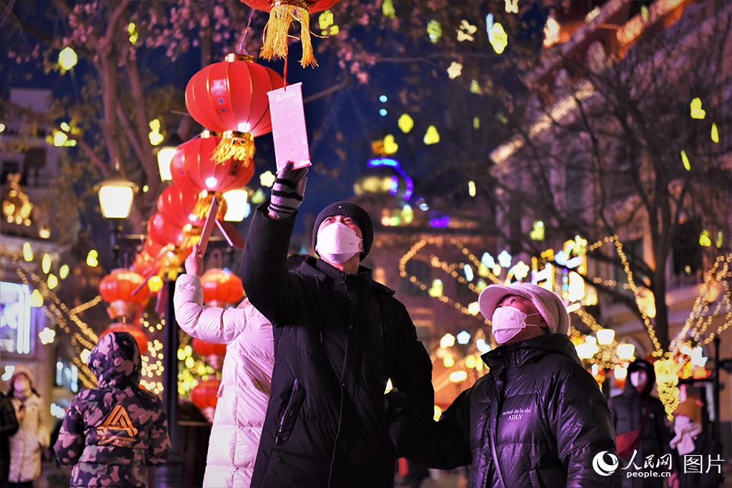 2月2日，在黑龍江哈爾濱市中央大街，游客們賞花燈，猜燈謎。人民網 蘇靖剛攝