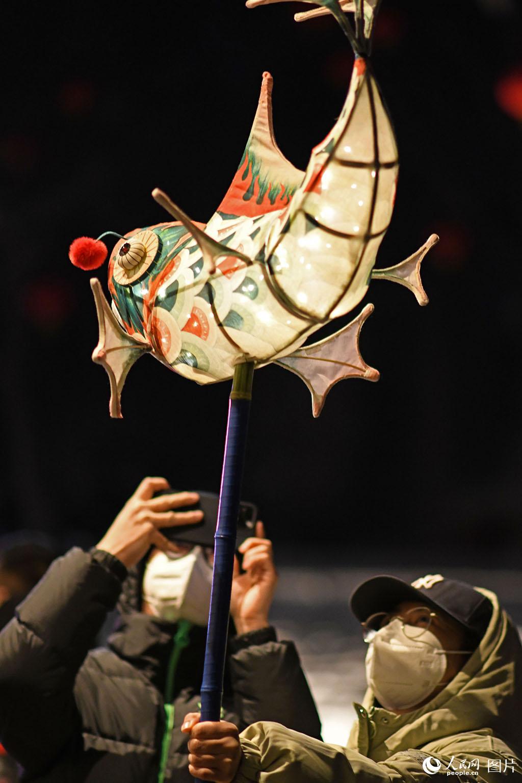 2月4日，在北京石景山區模式口大街，市民趙先生和呂小姐帶著自制的魚型花燈來到花燈會上拍照留念。人民網記者 於凱攝