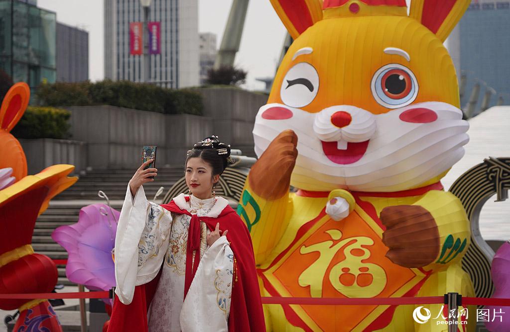 2月4日，在浙江杭州市拱墅區朝暉街道，身穿漢服的市民在兔年吉祥物前合影。人民網 章勇濤攝