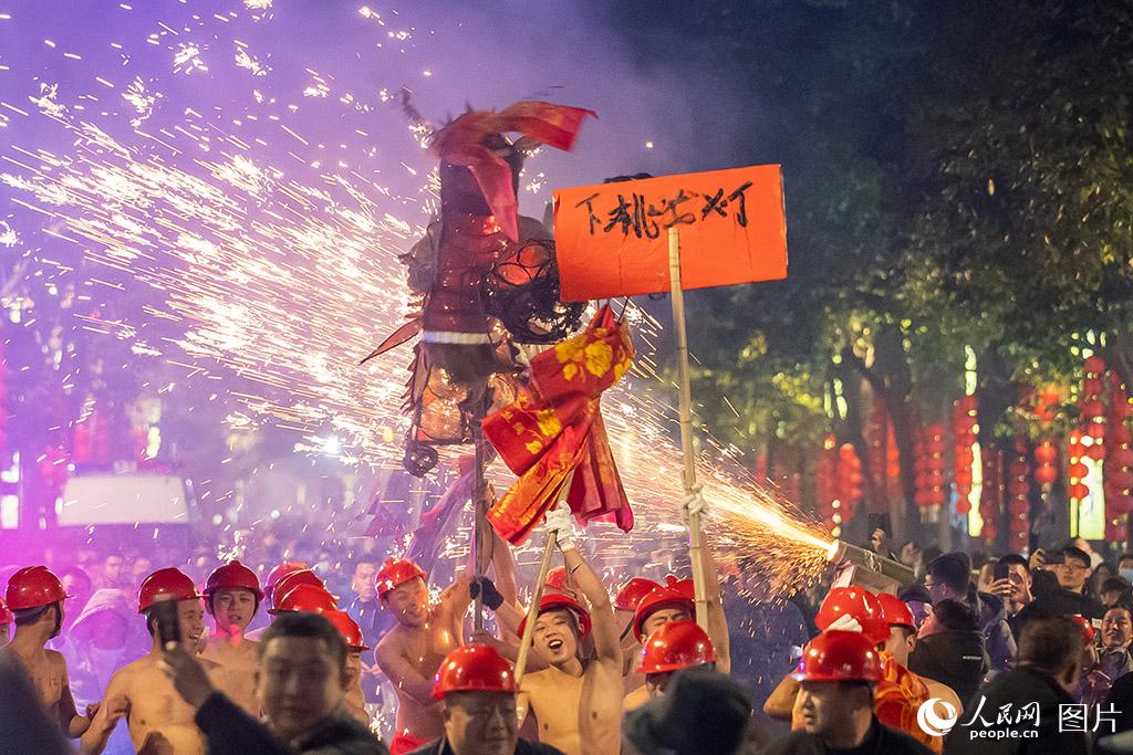 2月5日，在貴州台江縣舉行的國家級非物質文化遺產“舞龍噓花”活動中，群眾用噓花筒對著龍噓花，舞龍者赤身迎著火花狂舞，現場一片歡樂的氛圍。人民網記者 涂敏攝