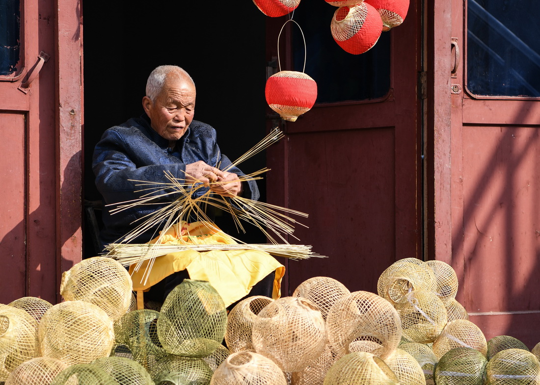 王學坤在編織竹篾燈籠（2月4日攝）。