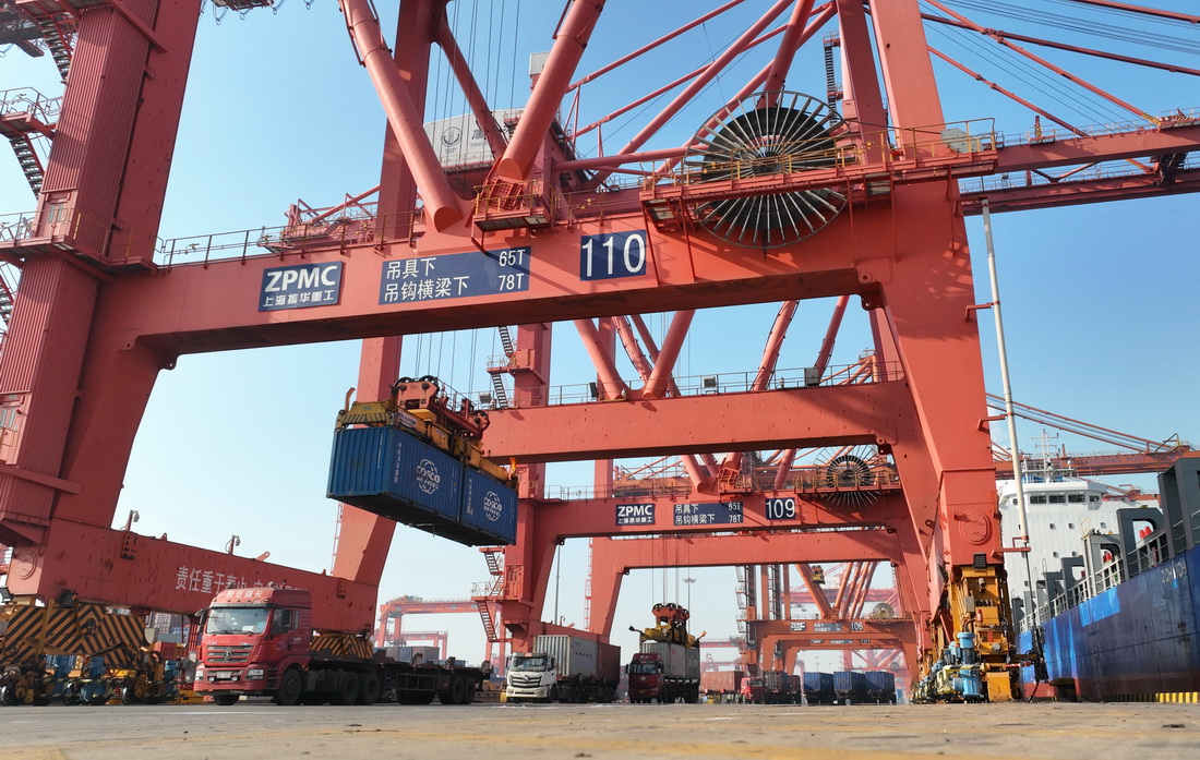 2月8日，唐山港京唐港區的工人在集裝箱碼頭操作機械設備吊裝集裝箱。