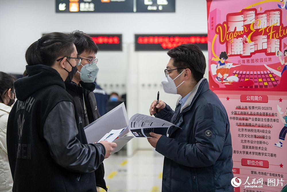 2月8日，北京市教委所屬北京高校大學生就業創業指導中心雙選會大廳迎來春季首場線下雙選會，吸引眾多高校畢業生前來應聘。圖為求職學生與招聘單位代表（右一）交流。人民網記者 翁奇羽攝