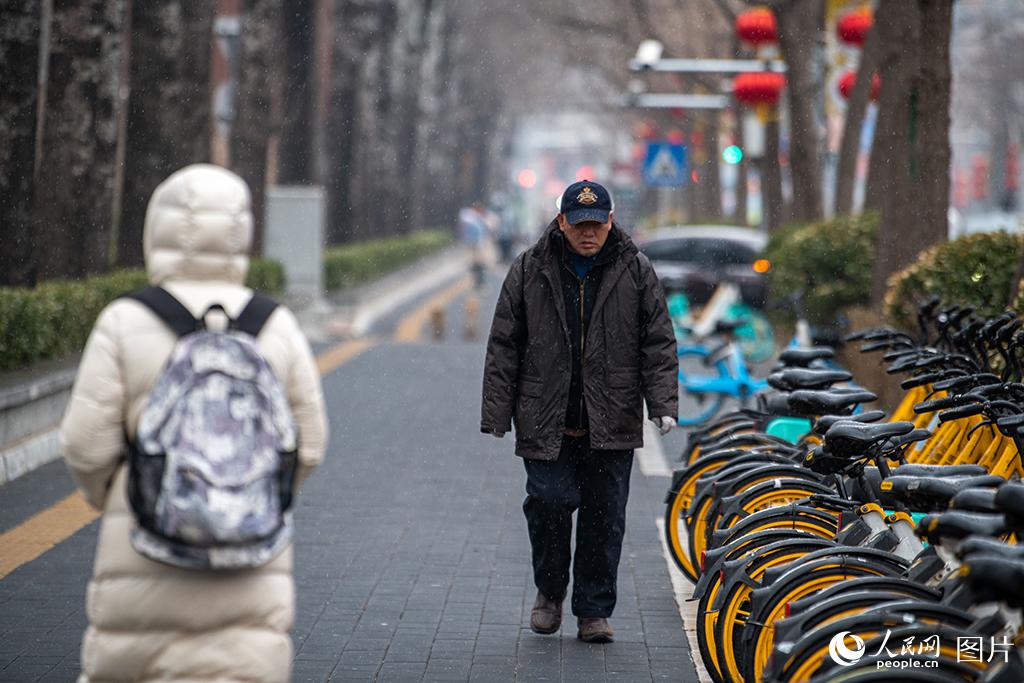 2月9日，北京迎來降雪，市民在雪中出行。人民網記者 翁奇羽攝