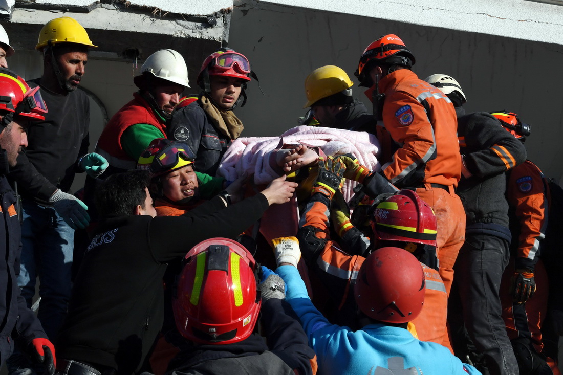 2月9日，在土耳其哈塔伊省安塔基亞市，中國救援隊與土耳其救援隊轉移一名救出的女性幸存者。新華社記者 沙達提 攝