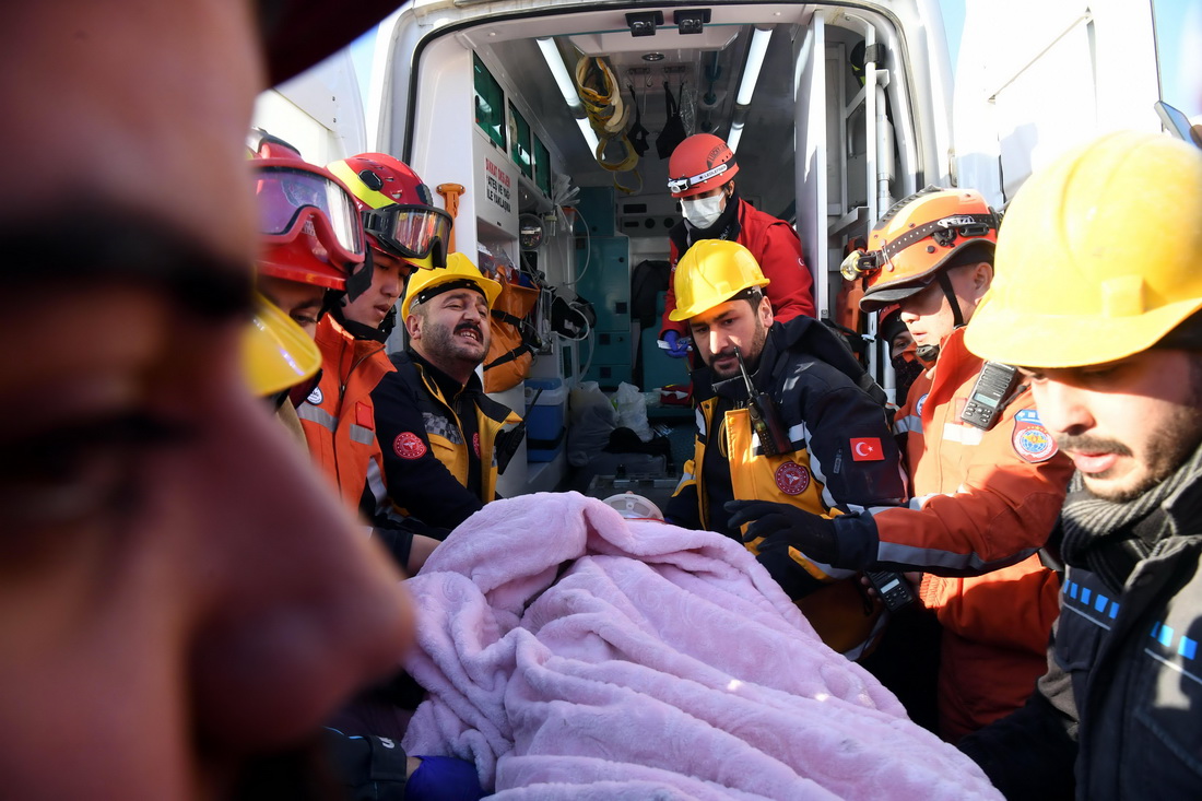 2月9日，在土耳其哈塔伊省安塔基亚市，中国救援队与土耳其救援队转移一名救出的女性幸存者。新华社记者 沙达提 摄
