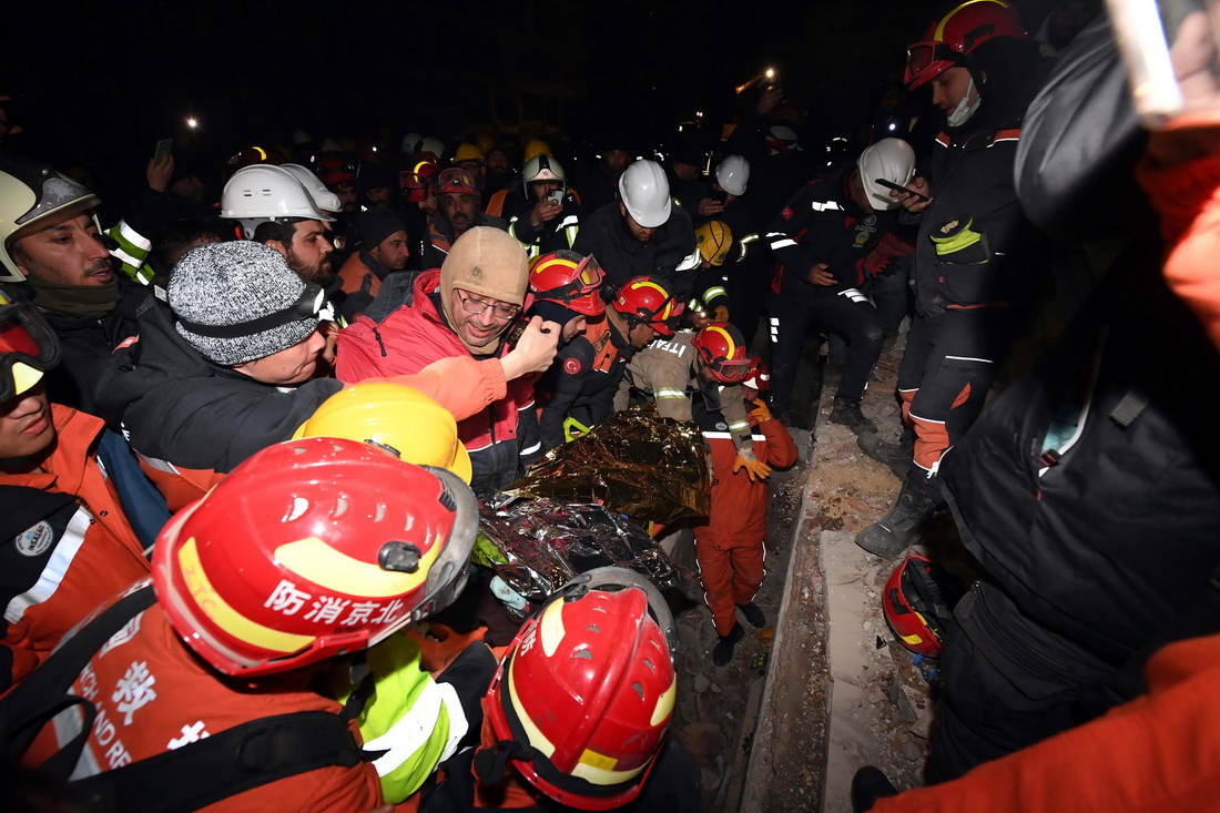 2月9日晚，在土耳其哈塔伊省安塔基亞市，中國救援隊與土耳其救援隊合力營救出的幸存者被抬出廢墟。 新華社記者 沙達提 攝