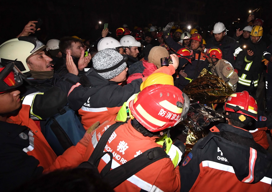 2月9日晚，在土耳其哈塔伊省安塔基亞市，中國救援隊與土耳其救援隊合力營救出的幸存者被抬出廢墟。新華社記者 沙達提 攝