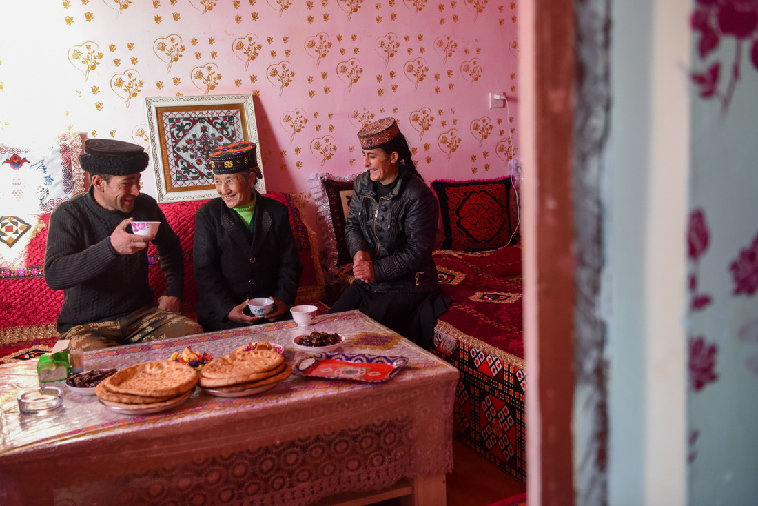 新疆塔什库尔干塔吉克自治县塔提库力易地扶贫搬迁安置点，村民在家中休息聊天（2022年12月20日摄）。新华社记者 丁磊 摄