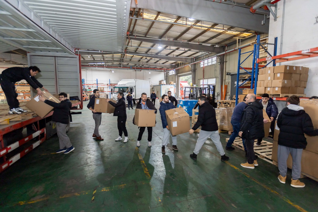 2月11日，志願者在倉庫內運送物資。