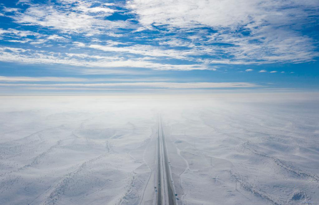 阿勒泰至乌鲁木齐的高速公路，穿越古尔班通古特沙漠（2023年1月16日摄，无人机照片）。新华社记者 胡虎虎 摄