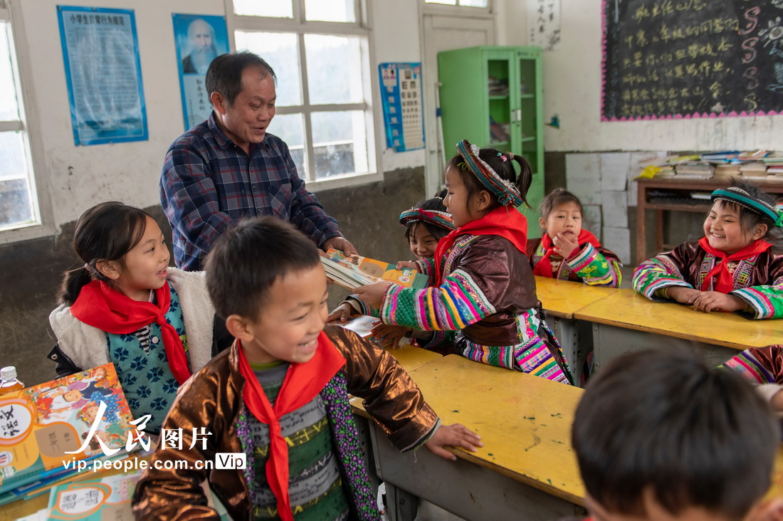 2023年2月16日，贵州省从江县西山镇中寨教学点教师孟荣达给学生发新书。