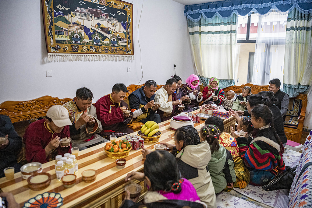 在位于森布日安置点的家中，石秀次仁一家正在吃“古突”（2月19日摄）。