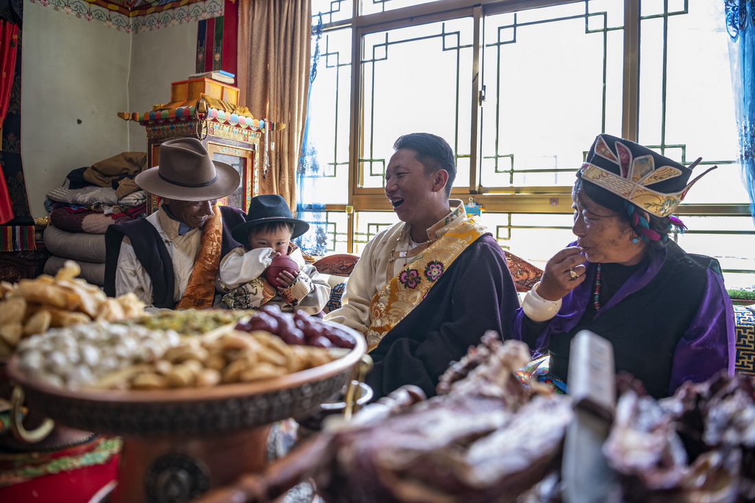 2月20日，在位於西藏拉薩市墨竹工卡縣門巴鄉的家中，扎西次仁（左一）一家在聊天、享用美食。新華社記者 孫非 攝