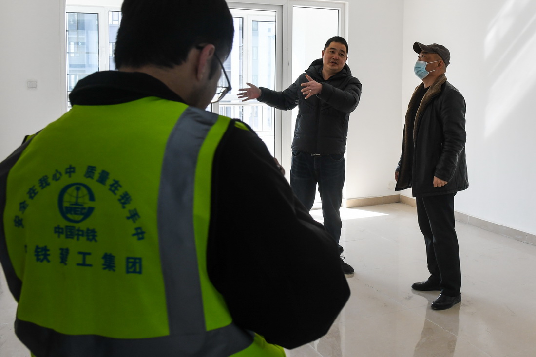 2月21日，回迁居民庄教滨（右）在中铁建工集团技术人员陪同下验收新居。