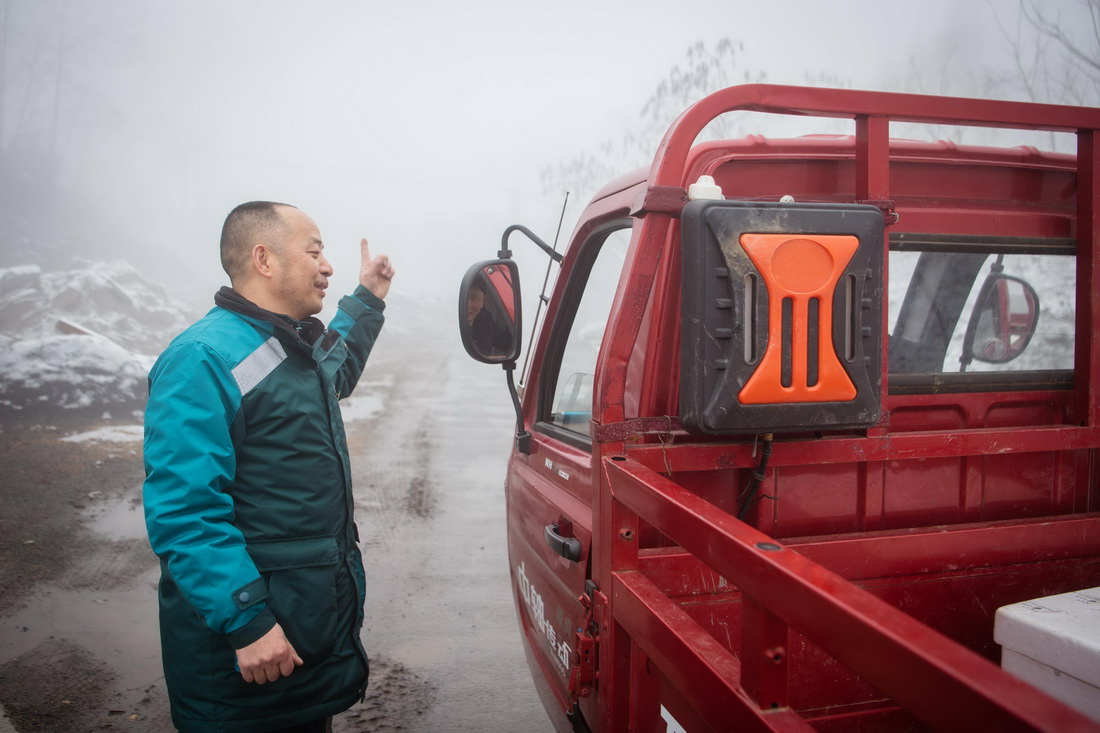 2月23日，陳祖章在送件路上與村民交談。