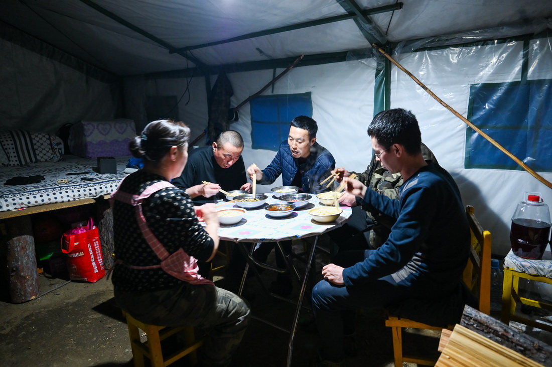 2月22日，烏龍岱林場402工隊職工在駐點的帳篷內吃晚飯。