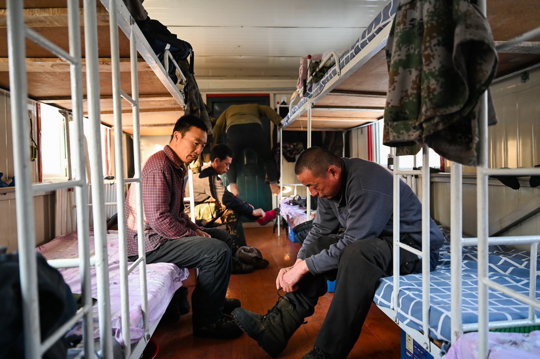 2月23日早晨，烏龍岱林場402工隊職工在駐點的移動板房內穿上衣物准備上山作業。