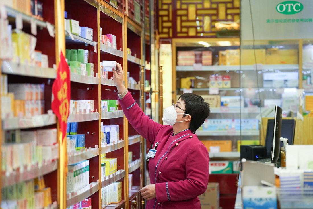 在白塔寺药店，张海鸥在查看药店内的药品（2月22日摄）。