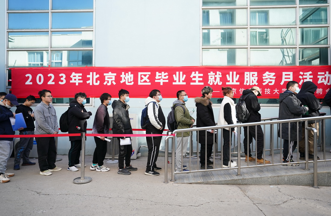 3月1日，在北京信息科技大學，求職學生排隊等候進入招聘會現場。