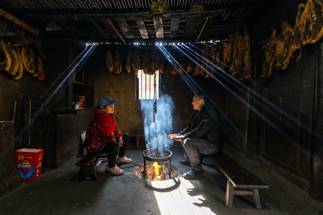2月14日，郑望春（右）在村民甘绍芝家中了解她家生产生活中需要解决的问题。