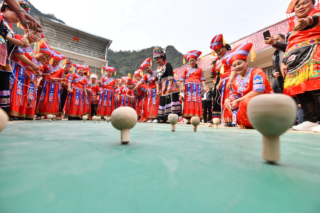 3月5日，在广西大化瑶族自治县大化镇仁良村，妇女参加陀螺比赛。
