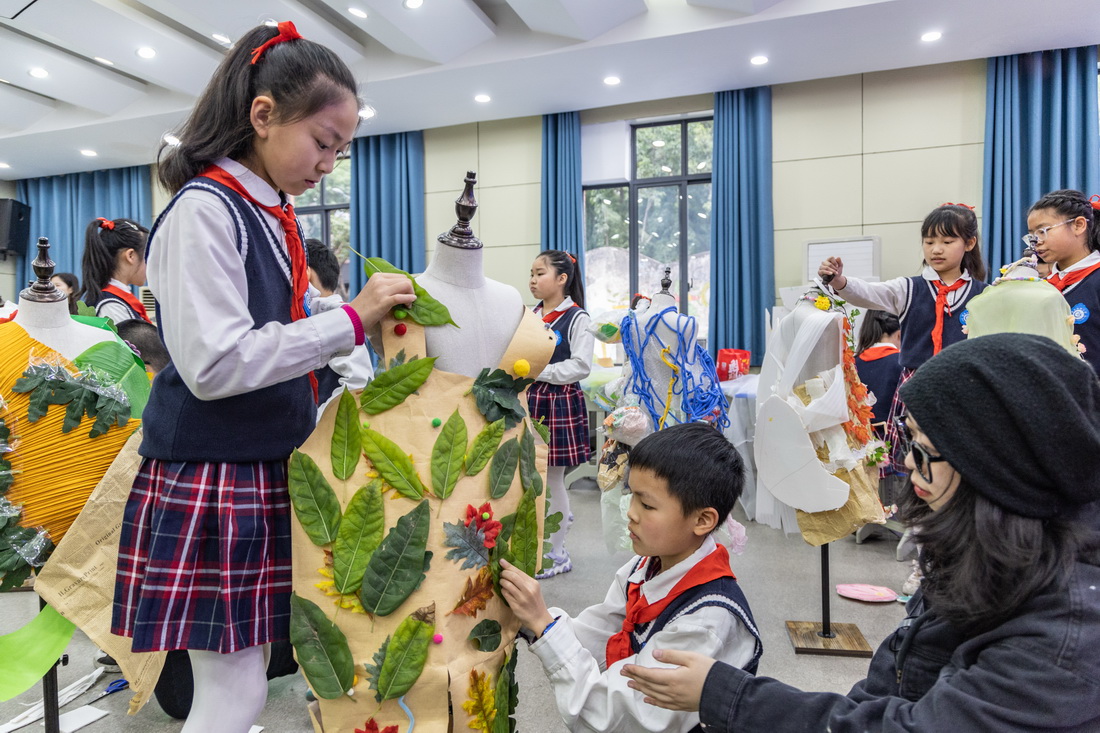 3月10日，重庆市九龙坡区铁路小学的学生们在老师的指导下制作环保服装。