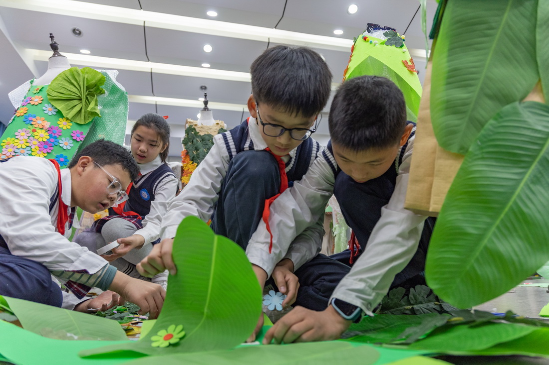 3月10日，重庆市九龙坡区铁路小学的学生们在制作环保服装。