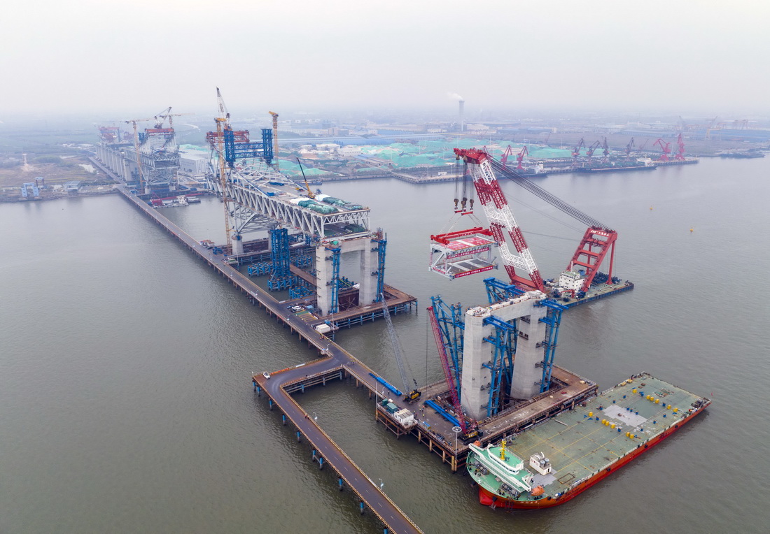 3月20日，中交二航局建設者在常泰長江大橋主航道橋泰州側施工現場進行首節段鋼桁梁架設（無人機照片）。