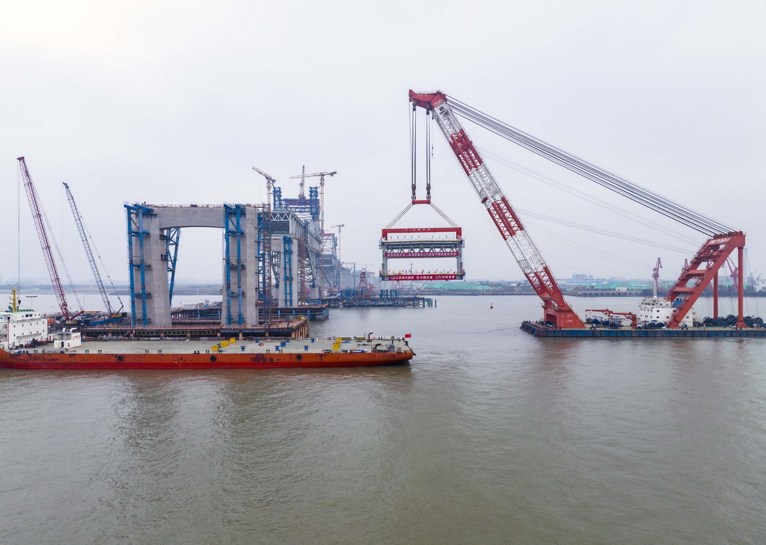 3月20日，中交二航局建設者在常泰長江大橋主航道橋泰州側施工現場進行首節段鋼桁梁架設（無人機照片）。