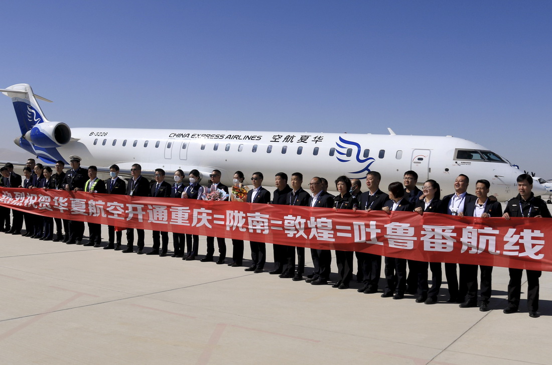3月26日，由华夏航空执飞的重庆-陇南-敦煌-吐鲁番往返航线正式通航，这是首航航班机组人员与机场工作人员在甘肃敦煌莫高国际机场合影。