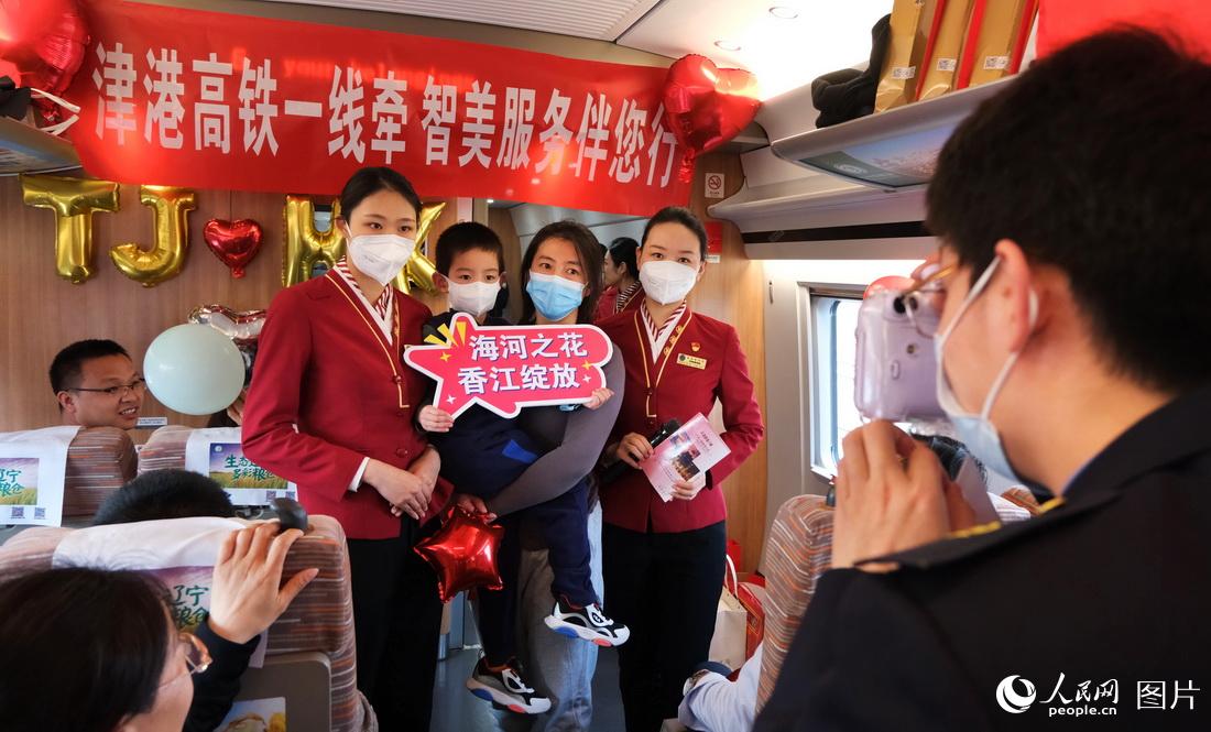 4月1日，在天津西至香港西九龍G305次列車上，乘務人員為旅客拍照合影留念。