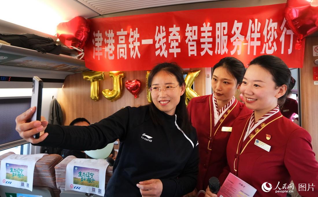 4月1日，在天津西至香港西九龍G305次列車上，旅客與乘務人員合影留念。