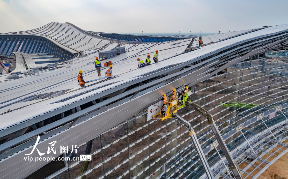 4月3日，海口新海滾裝碼頭客運綜合樞紐站項目現場，施工人員正在進行金屬屋面、玻璃幕牆的局部收尾施工。