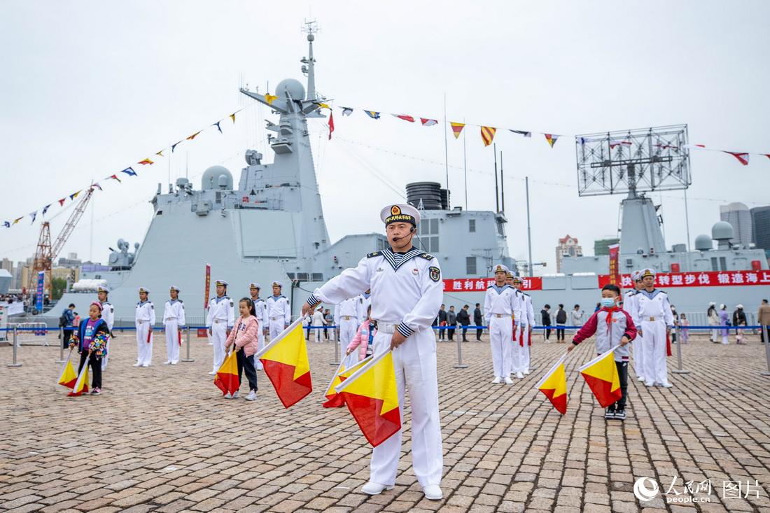 4月23日，山東青島港，海軍成立紀念日艦艇開放活動現場，海軍士兵向觀眾展示海軍旗語文化。