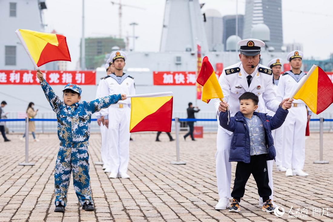 4月23日，山東青島港，海軍成立紀念日艦艇開放活動現場，小朋友在體驗海軍旗語文化。