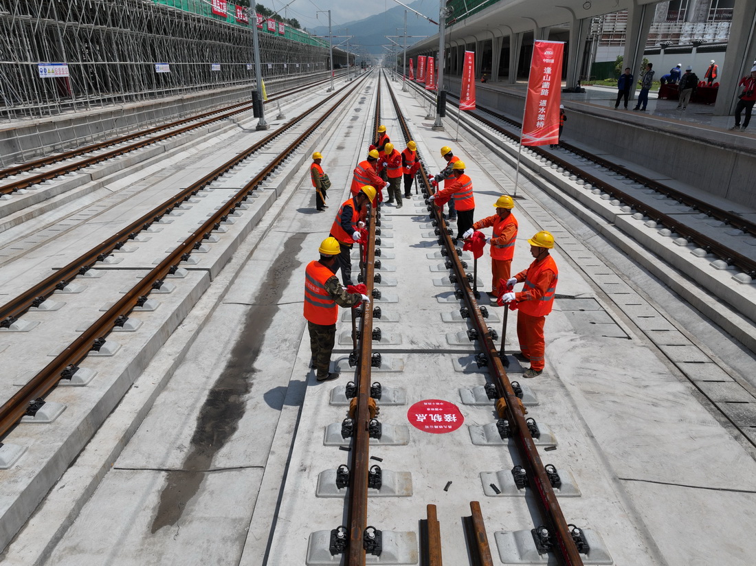 4月26日，在昌景黃高鐵浮梁東站，工作人員在緊固螺栓，將對接好的鋼軌固定。