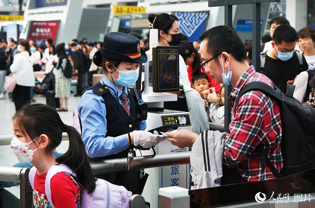 5月3日，铁路天津西站服务人员正在为旅客验票乘车。杨宝森摄