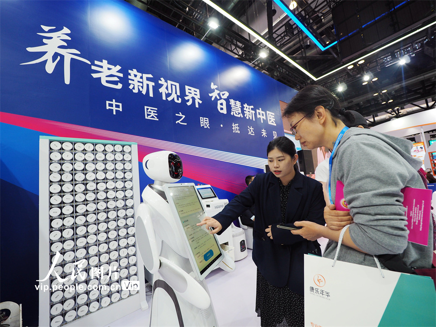 5月6日，北京国家会议中心第九届中国国际养老服务业博览会上，观众在体验“中医面部诊疗机器人”。