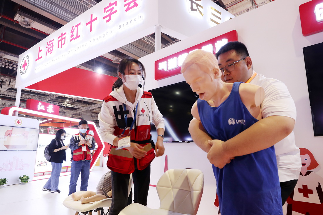 5月8日，一位参观者在工作人员指导下体验气道梗阻应急救援操作。