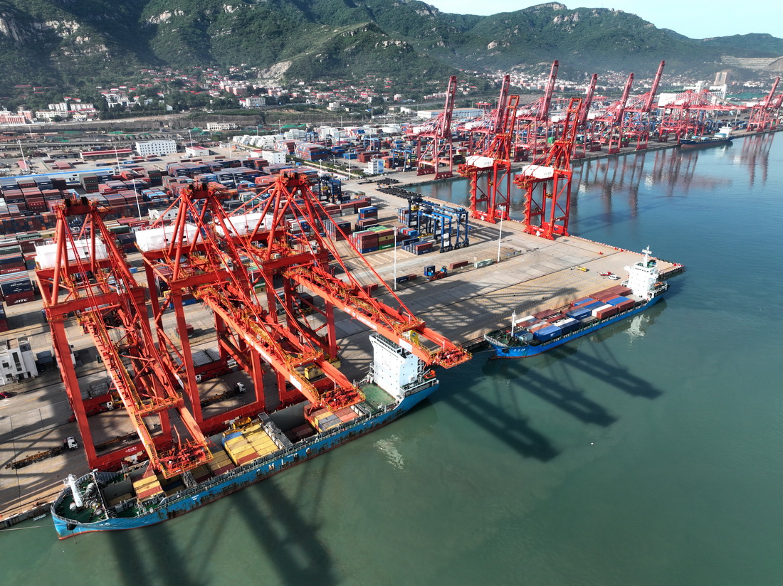 5月9日，在江蘇連雲港港集裝箱碼頭，貨輪停靠在泊位上裝卸集裝箱（無人機照片）。新華社發（王春攝）
