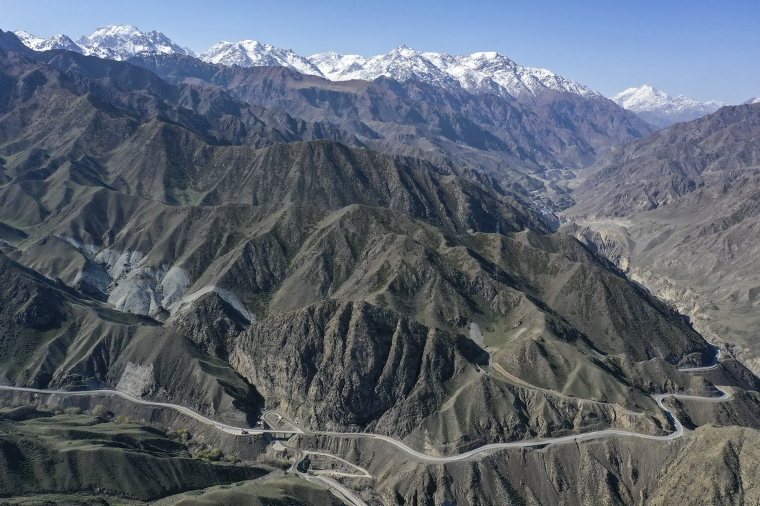 5月11日拍攝的新疆獨庫公路。海拔較低的山體積雪已消融，遠山更高海拔處依舊白雪皚皚（無人機照片）。