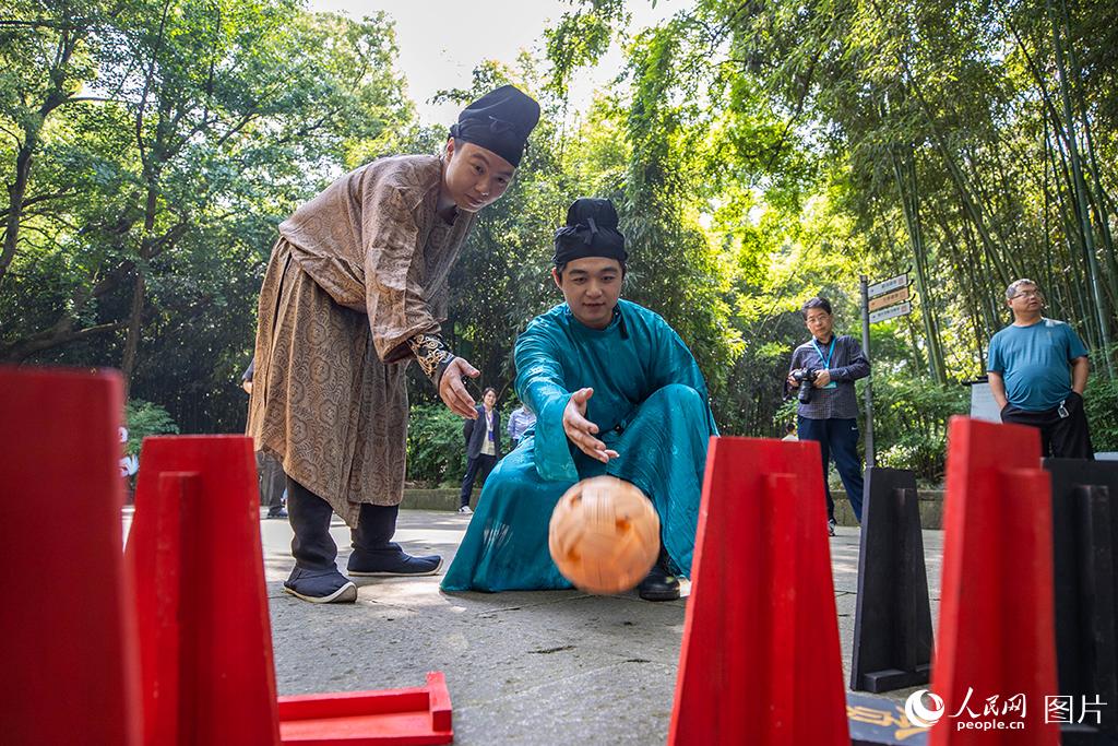 5月14日，游客們在浙江紹興蘭亭景區體驗傳統文化“木射”游戲。