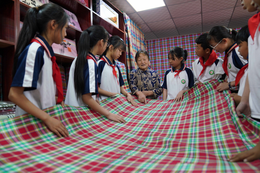 5月24日，民間藝人在河北省沙河市塔子峪村非遺傳習所內為小學生講解四匹繒布制作技藝。