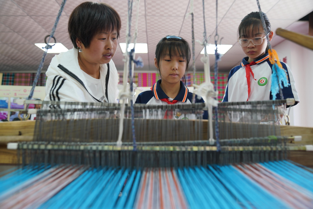 5月24日，小學生在河北省沙河市塔子峪村非遺傳習所內體驗四匹繒布制作技藝。