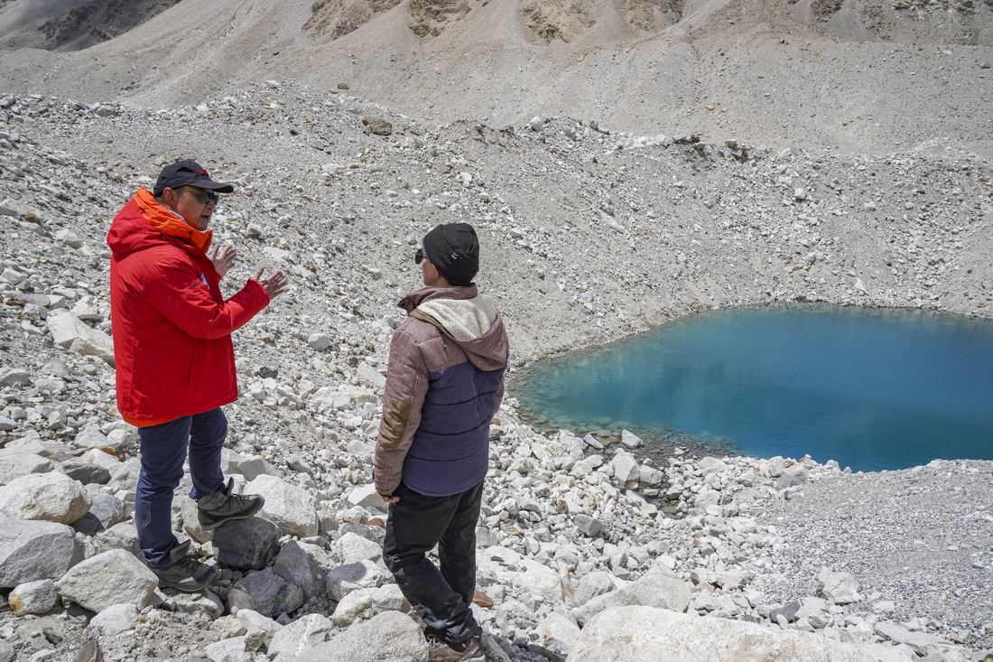 在珠峰海拔約5300米處，中國科學院西北生態環境資源研究院副院長康世昌（左）和科考隊員討論冰面湖的形成原因（5月14日攝）。新華社記者 孫非 攝