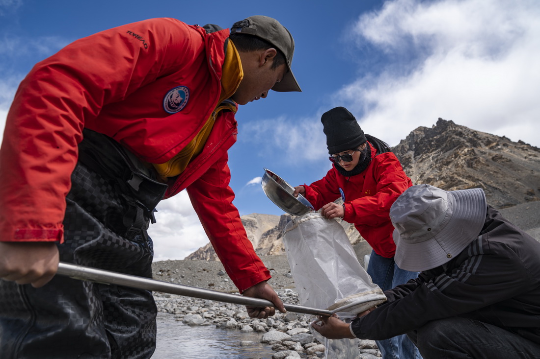 在珠峰登山大本營附近，來自西藏大學生態環境學院的科考隊員在採集水生生物樣本（5月22日攝）。新華社記者 孫非 攝