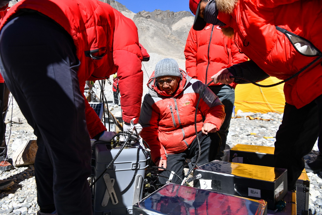 在珠峰登山大本營附近，第二次青藏科考高海拔氣象梯度觀測小組負責人趙華標（中）在指導科考登頂隊隊員架設自動氣象站（5月9日攝）。新華社記者 晉美多吉 攝