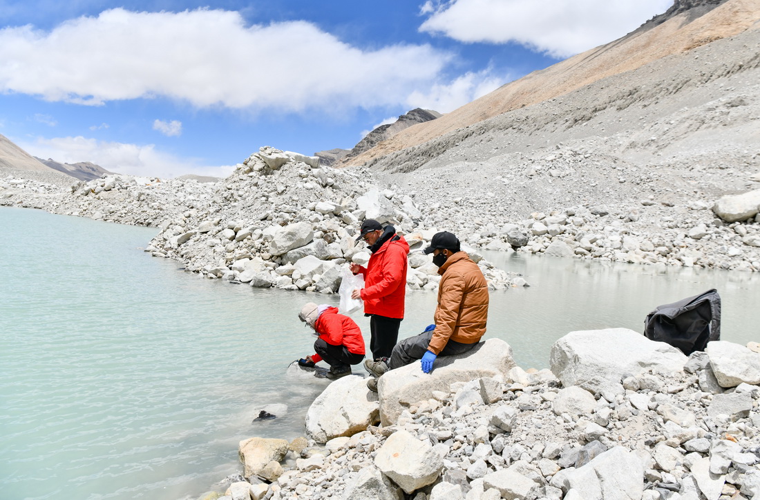 在珠峰海拔約5300米處，來自中國科學院青藏高原研究所的科考隊員在用水質儀檢測冰前湖水質（5月12日攝）。新華社記者 晉美多吉 攝
