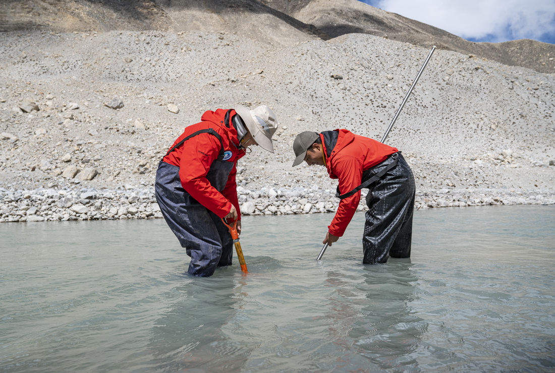 在珠峰登山大本營附近，來自西藏大學生態環境學院的科考隊員在收集水生生物樣本（5月22日攝）。新華社記者 孫非 攝